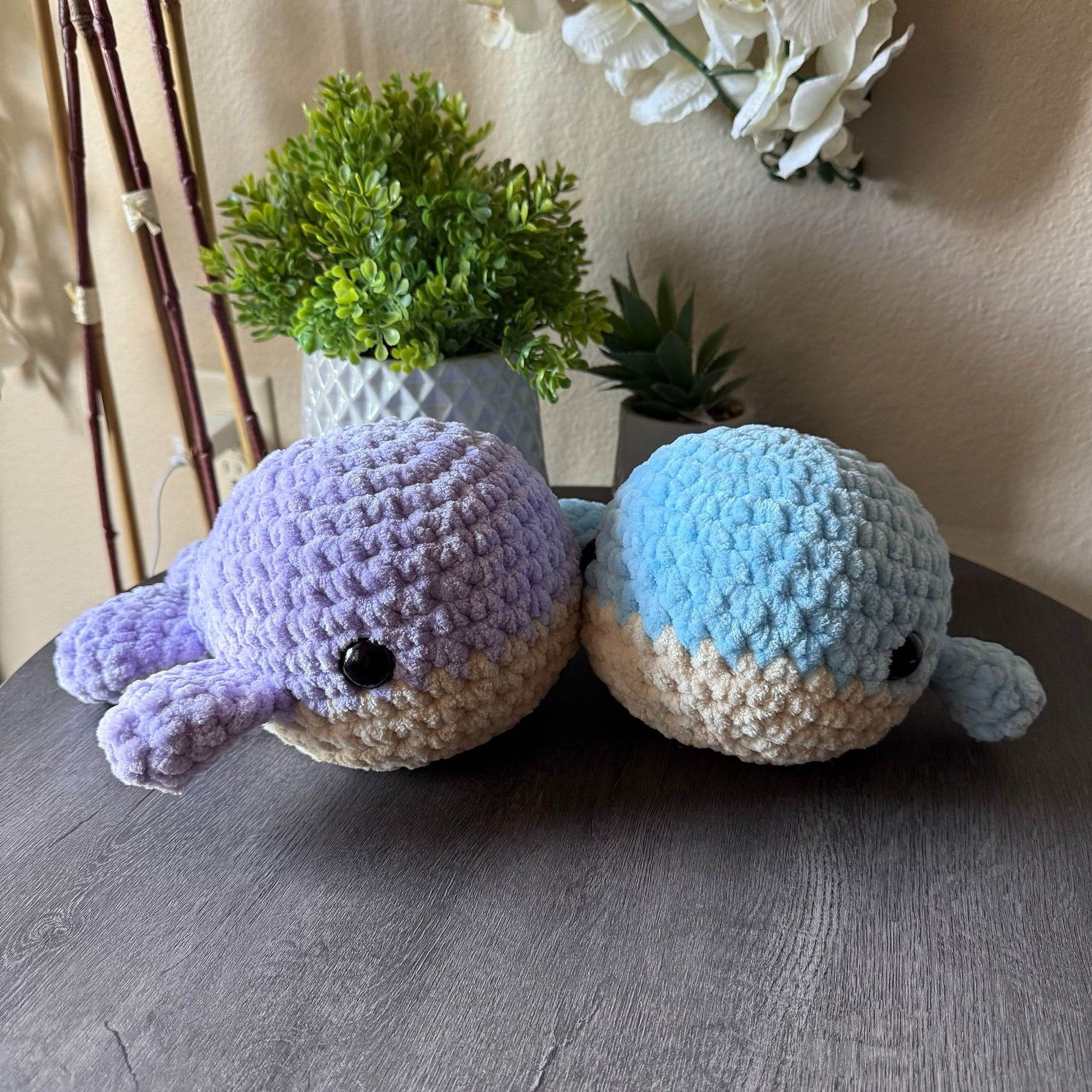 blue and purple jumbo whale plushie beside each other