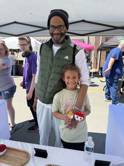 dad and daughter holding a mushroom and chicken nugget plushie