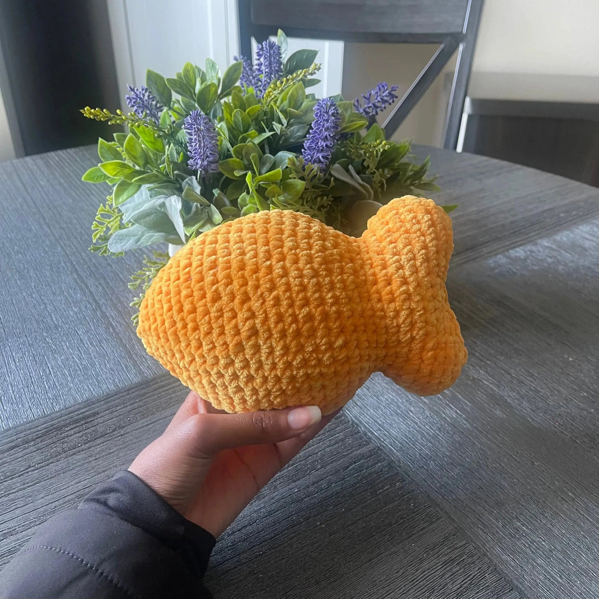 hand holding a goldfish plushie