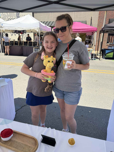mom and daughter holding a giraffe plushie