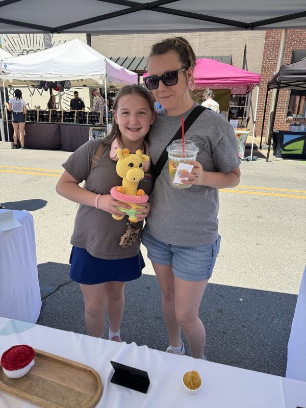 mom and daughter holding a giraffe plushie