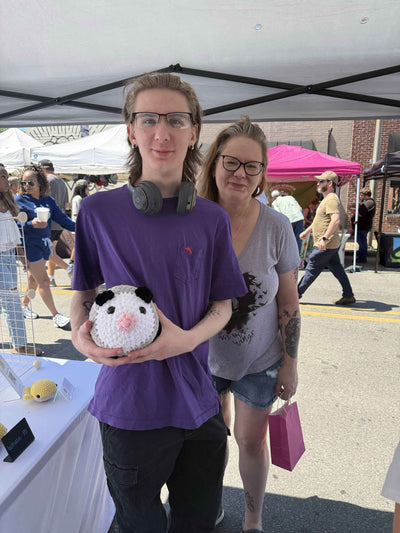 mom and son holding a jumbo opossum plushie