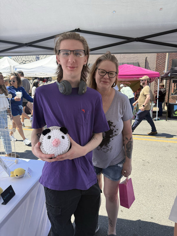 mom and son holding a jumbo opossum plushie