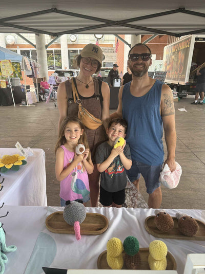 parents and siblings holding a capybara and whale plushie