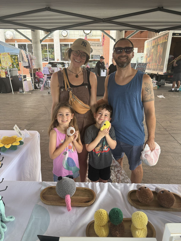 parents and siblings holding a capybara and whale plushie
